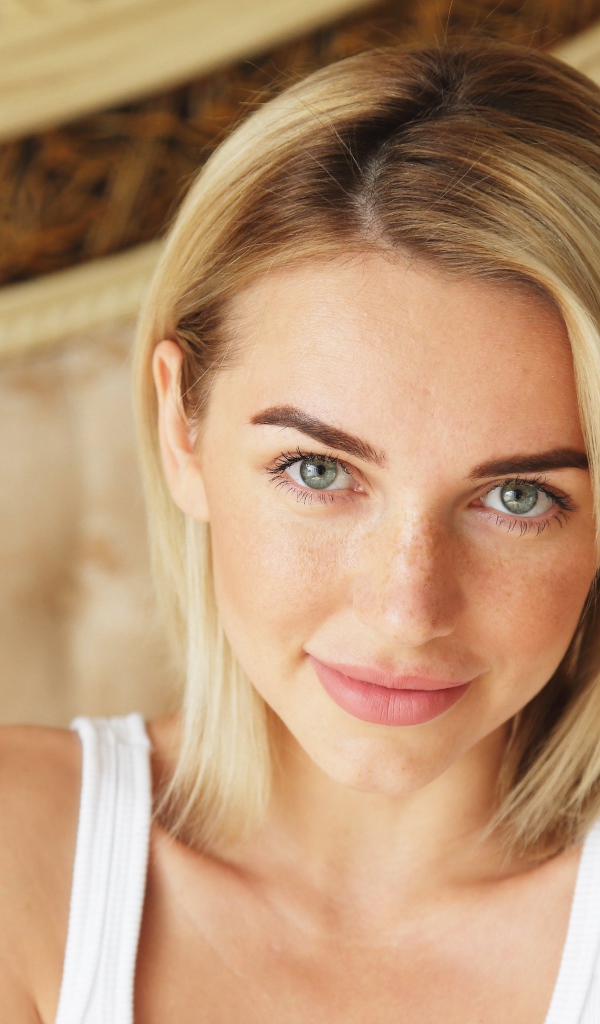 Нежная блондинка с зелеными глазами в белой майке