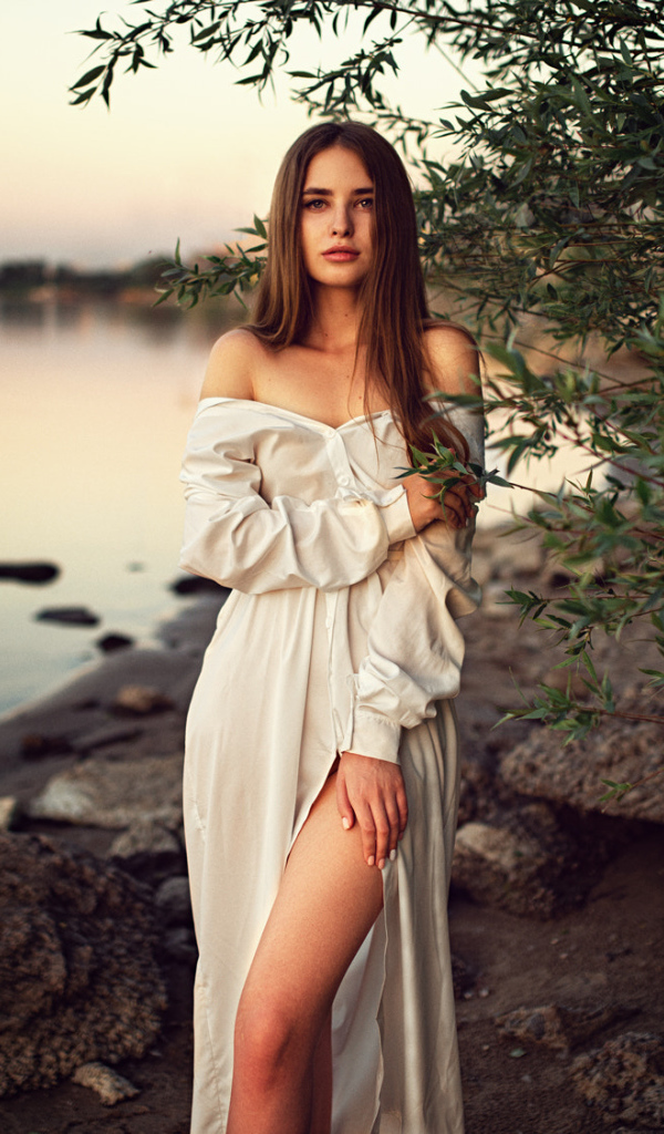 Девушка в красивом белом платье у воды