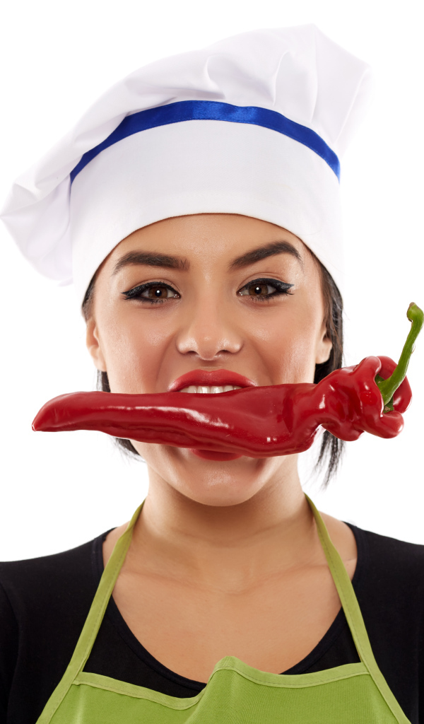 Девушка в шапке повара с красным перцем во рту на белом фоне