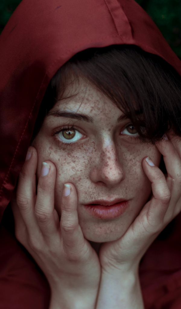 Девушка в красном плаще с веснушками на лице