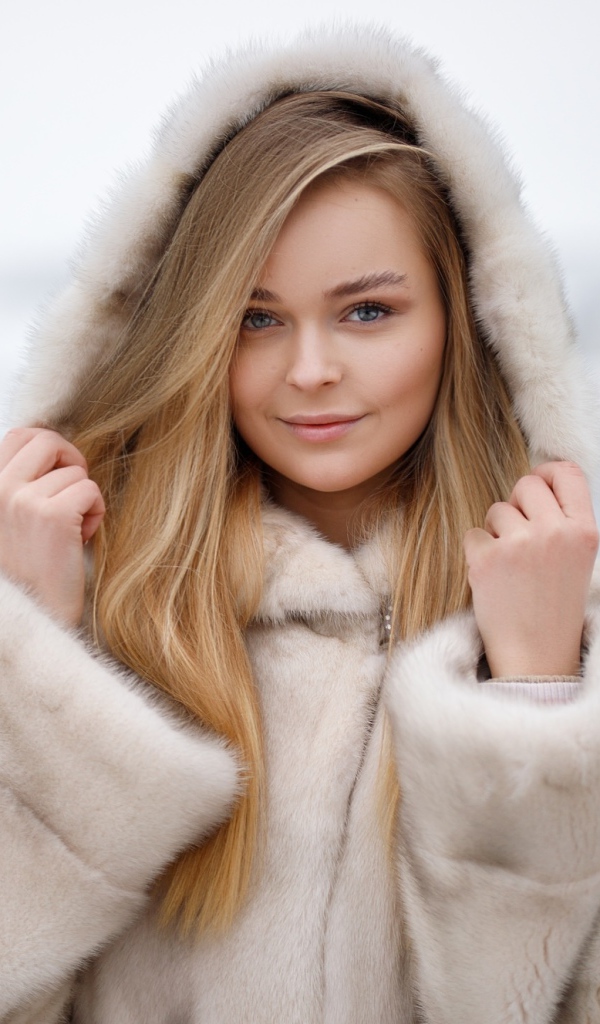 Девушка в теплой шубе на дороге зимой