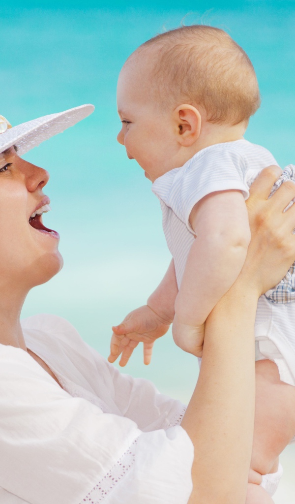 Девушка в белой шляпе с грудным ребенком в руках