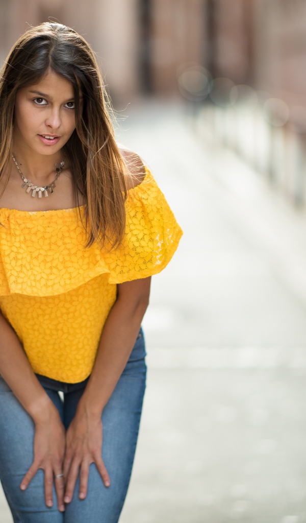 Девушка в джинсах стоит на улице 