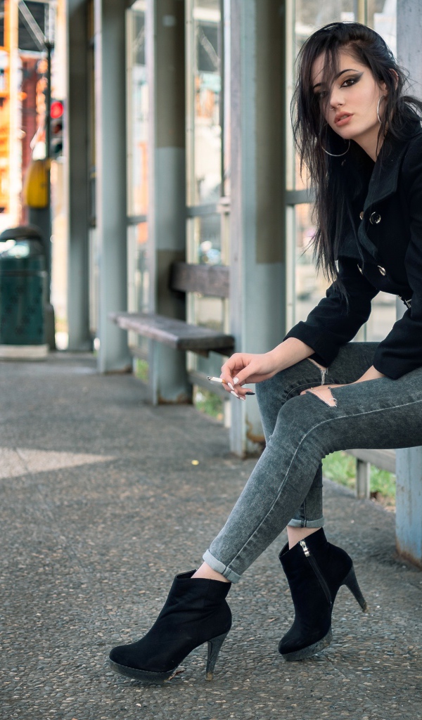 Девушка неформалка сидит на автобусной остановке