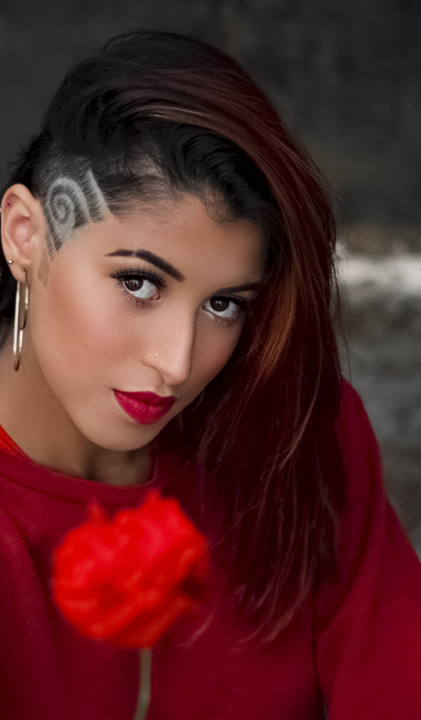 Девушка со стрижкой держит розу в руке