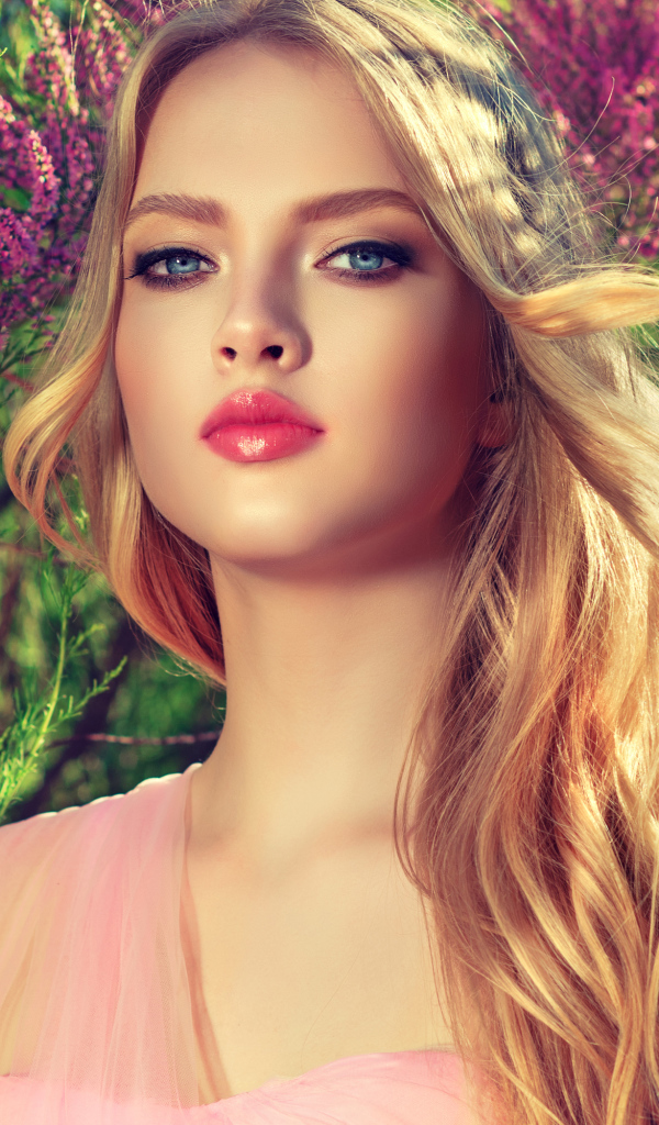 Девушка с красивыми голубыми глазами у цветущего дерева