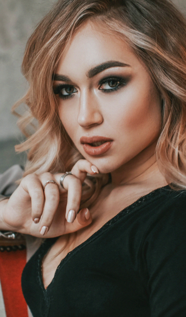 Горячая девушка с макияжем сидит на стуле