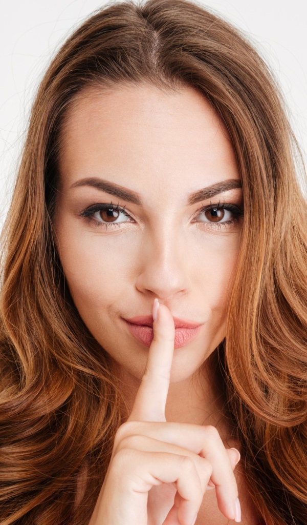 Длинноволосая шатенка с пальцем у губ 