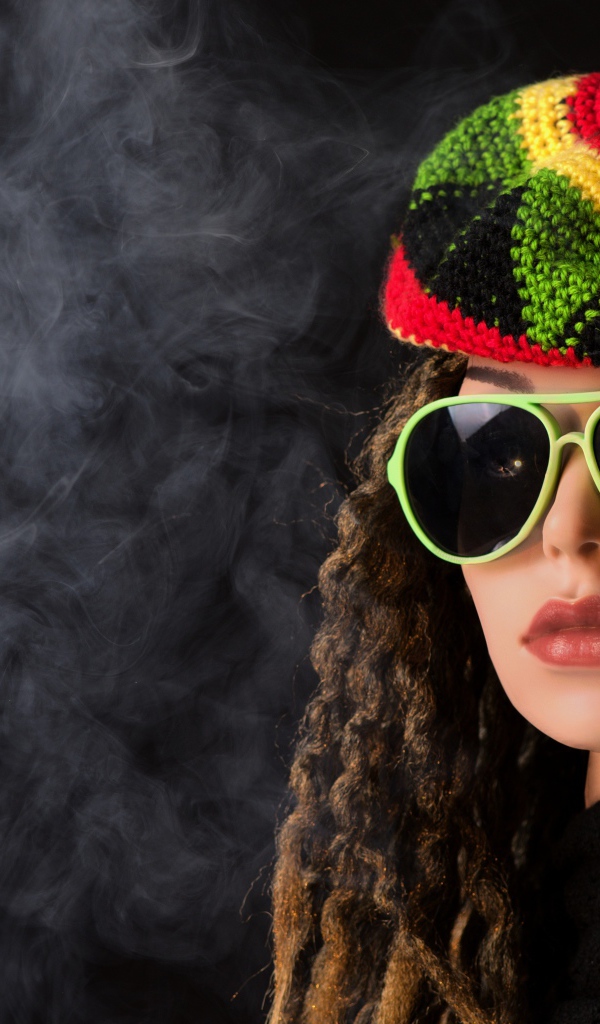 Девушка растаманка в черных очках в дыму