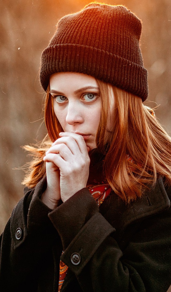 Рыжеволосая девушка в черной шапке в пальто 