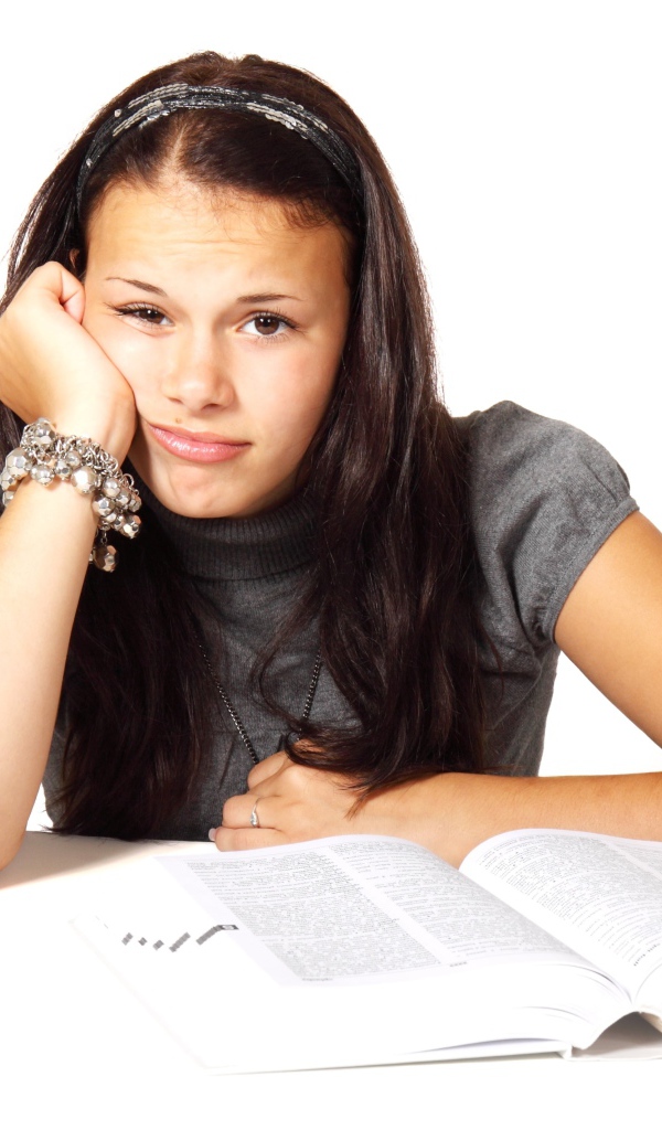 Грустная девушка читает книгу на белом фоне