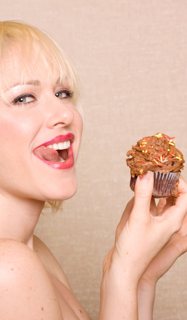 Блондинка с короткой стрижкой с кексом в руках