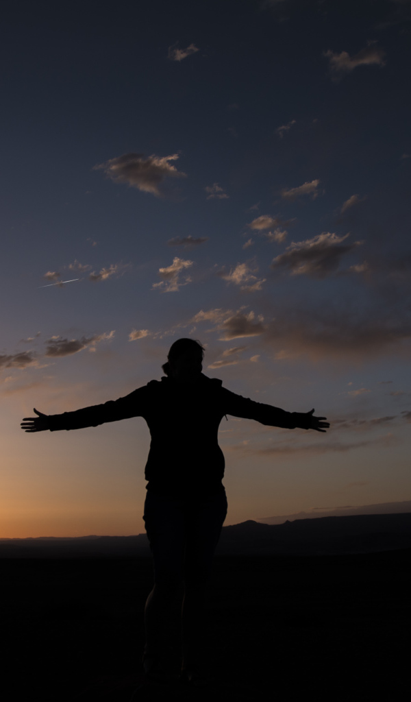 Силуэт девушки на фоне неба на закате