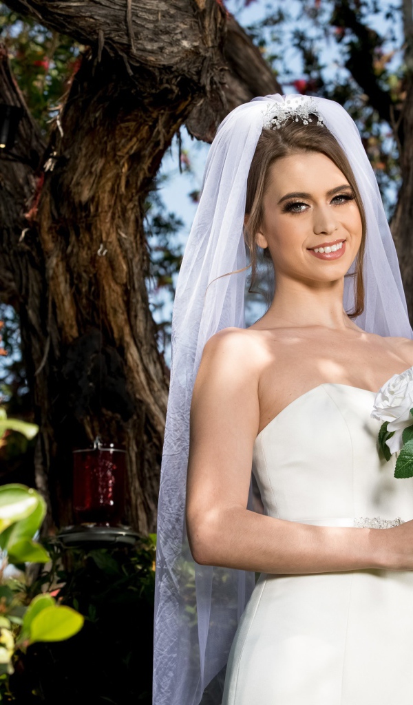 Улыбающаяся девушка в свадебном платье с букетом