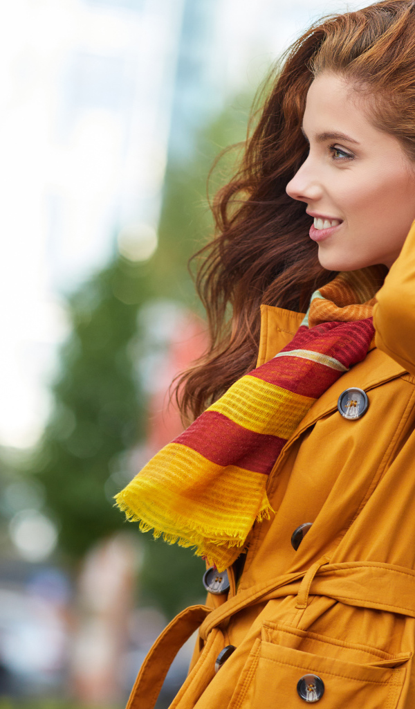 Улыбающаяся девушка в оранжевом пальто 