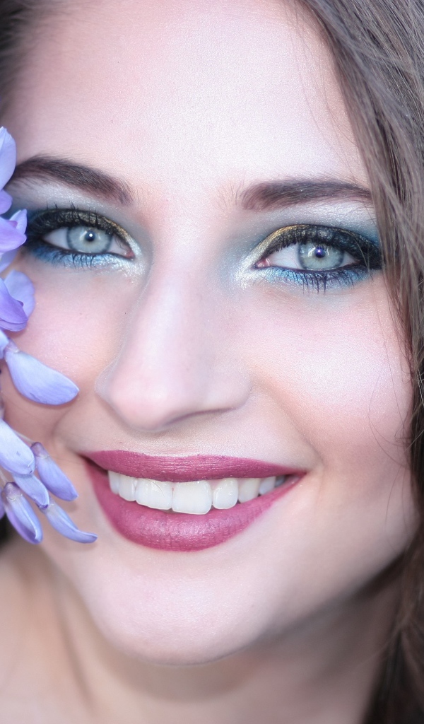 Улыбающаяся девушка с цветами глицинии