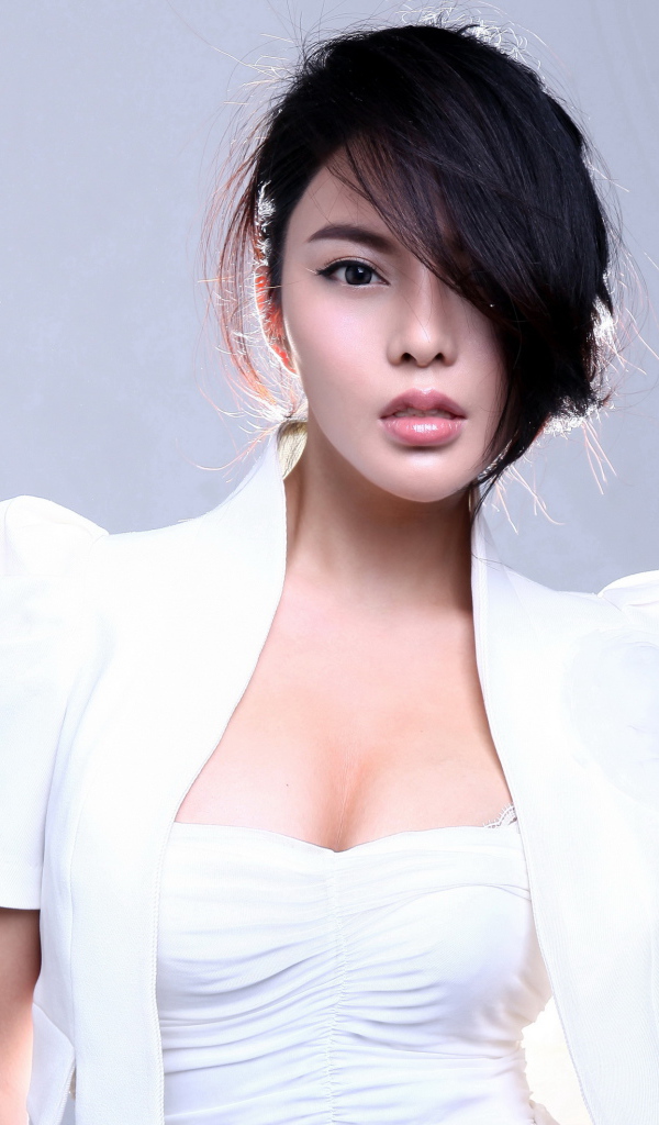 Стильная девушка азиатка в белом костюме на сером фоне