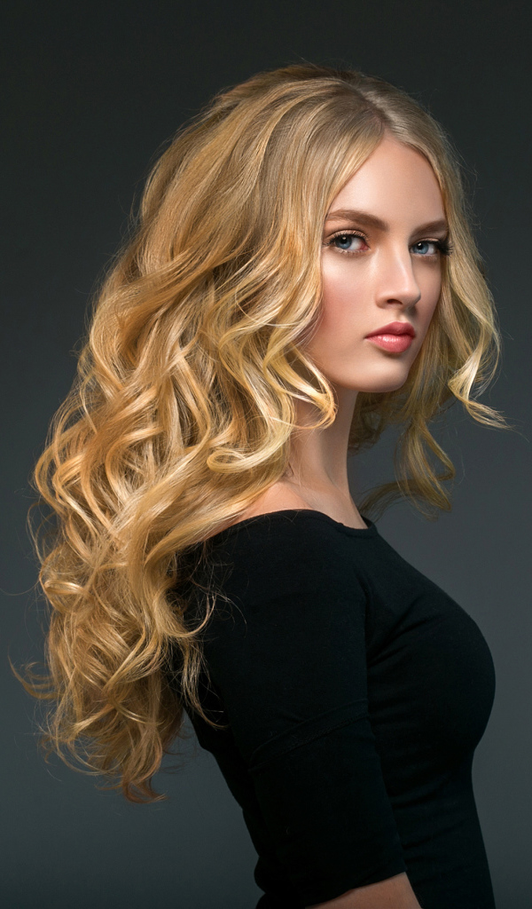 Стильная голубоглазая длинноволосая девушка в черном наряде