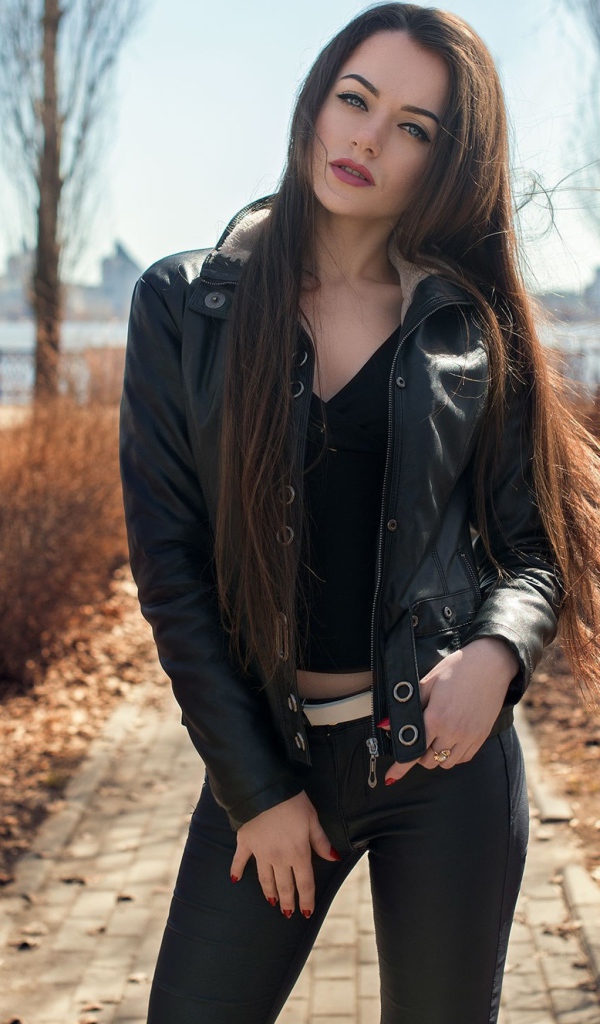 Стильная девушка в черной куртке в парке 