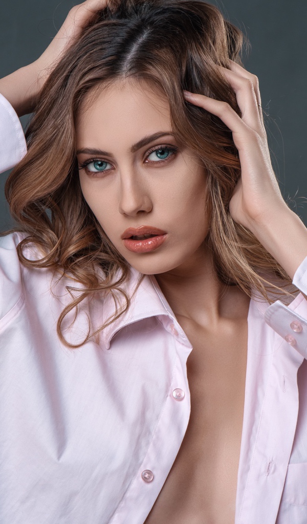 Стильная девушка в розовой рубашке на сером фоне