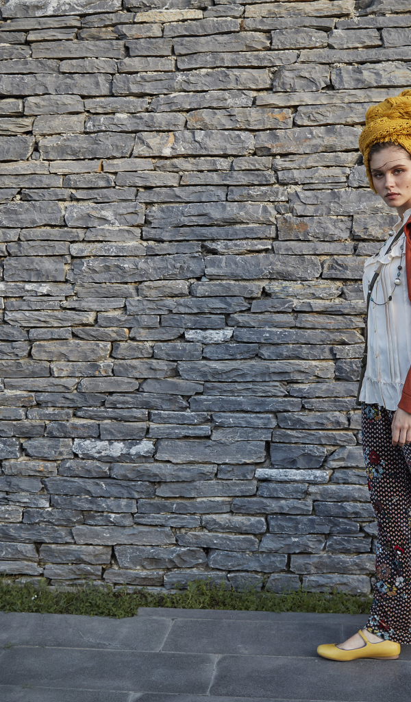 Стильная девушка на фоне стены 