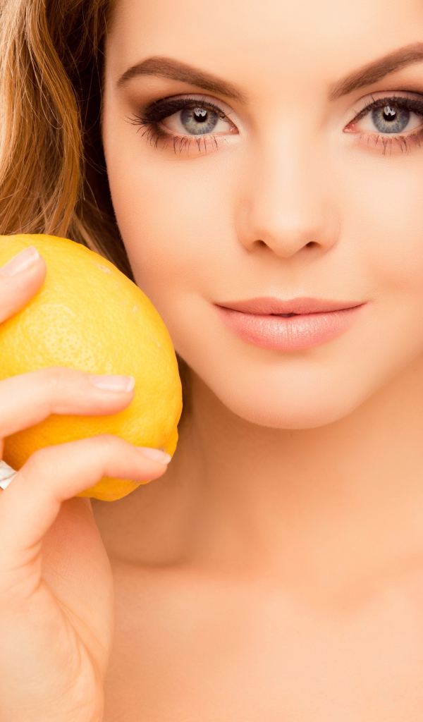 Нежная голубоглазая девушка с лимоном в руке