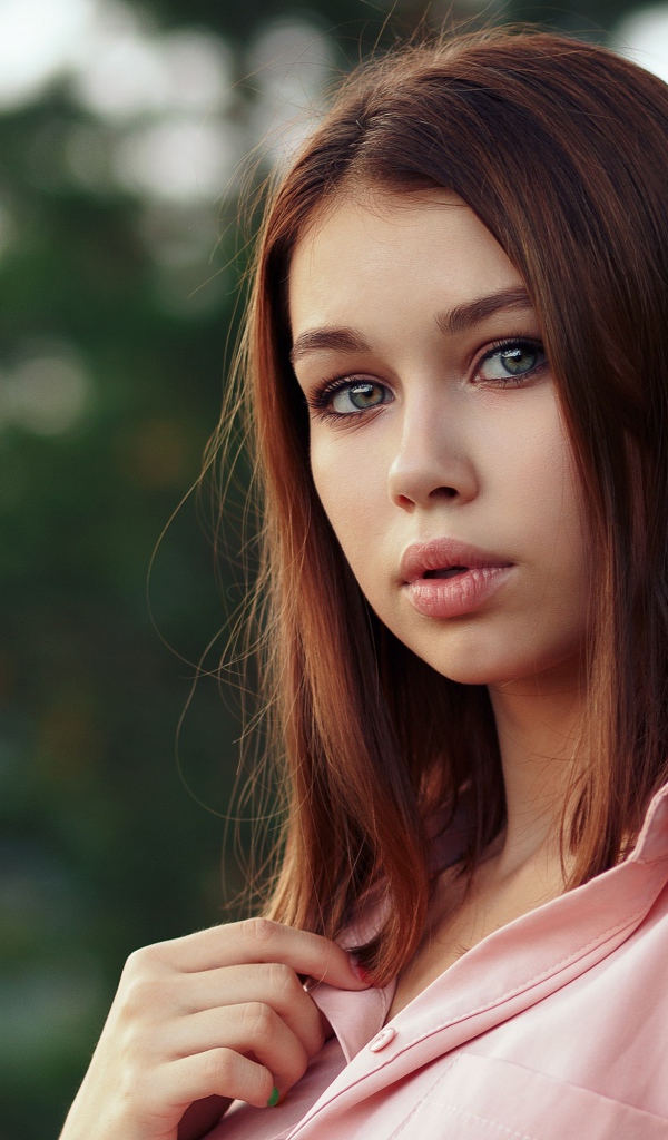 Нежная девушка стоит у дерева