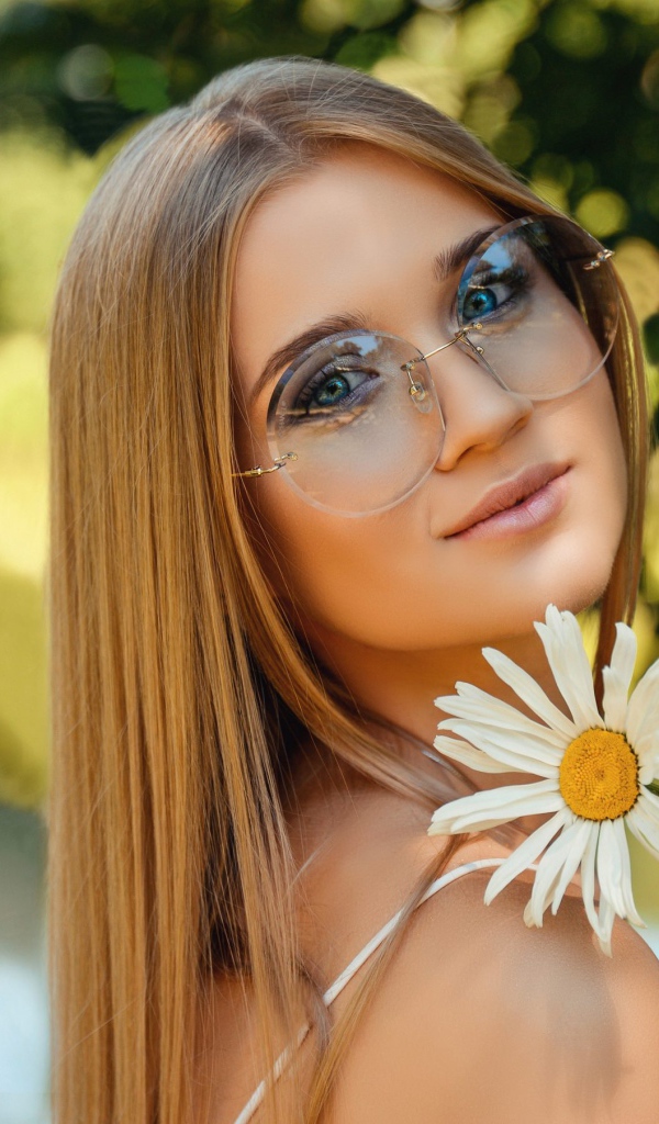 Девушка в очках с ромашкой в руке 