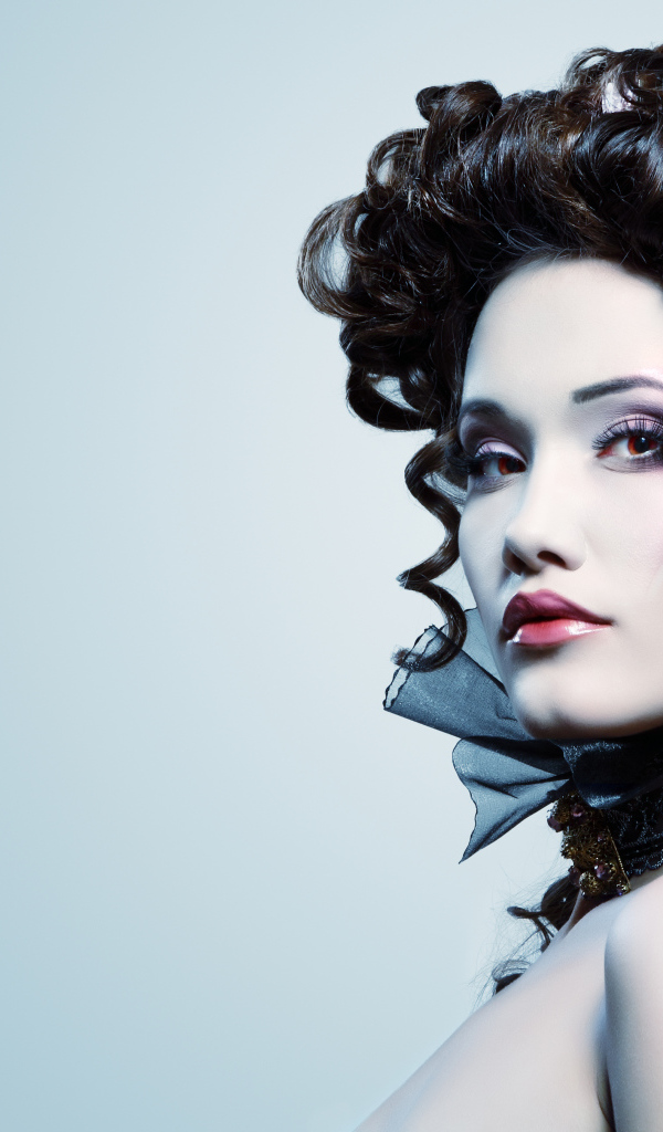 Девушка с необыной прической и макияжем на сером фоне