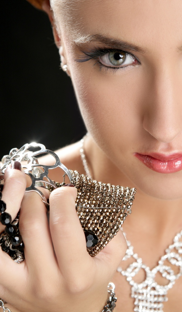 Девушка с красивыми глазами с украшениями в руках