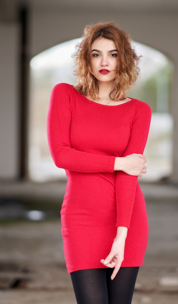 Молодая девушка в красном платье в старом здании