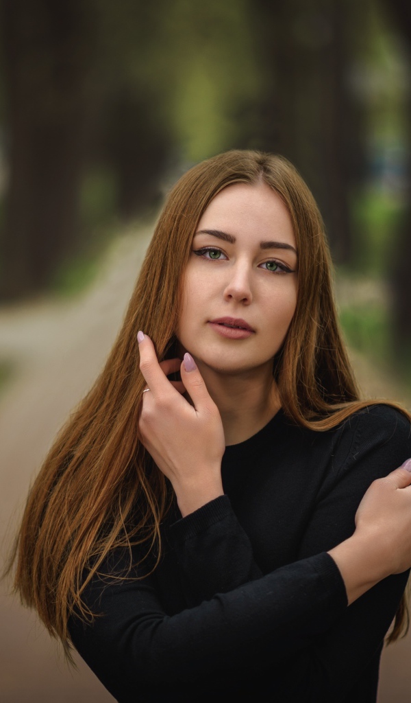 Молодая девушка в черном наряде в парке