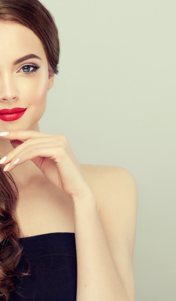 Молодая девушка с красивыми волосами на сером фоне