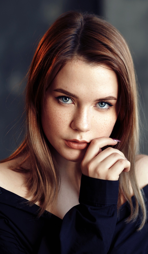 Молодая девушка с голубыми глазами в черной рубашке