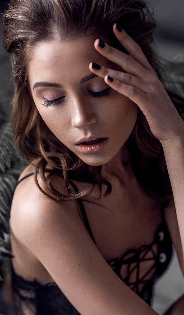 Молодая девушка с закрытыми глазами у цветка