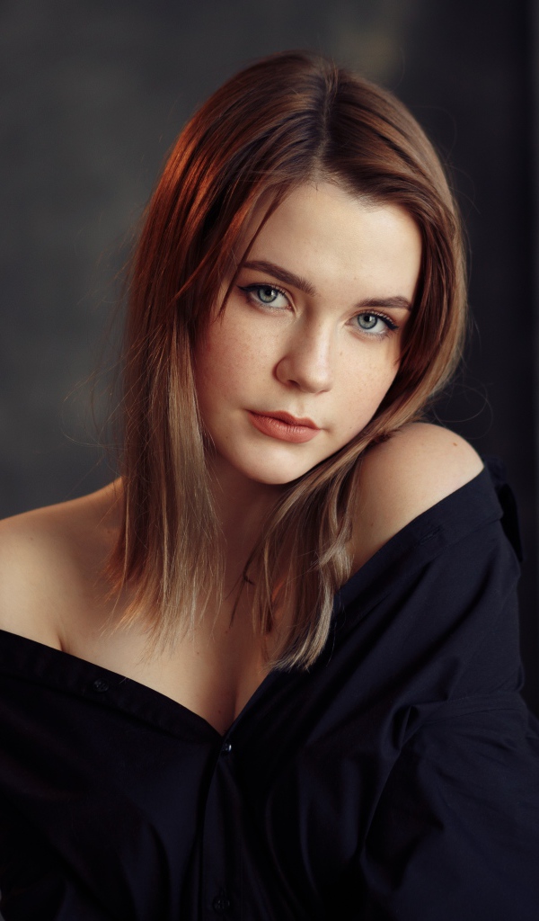 Молодая скромная девушка в черном наряде 