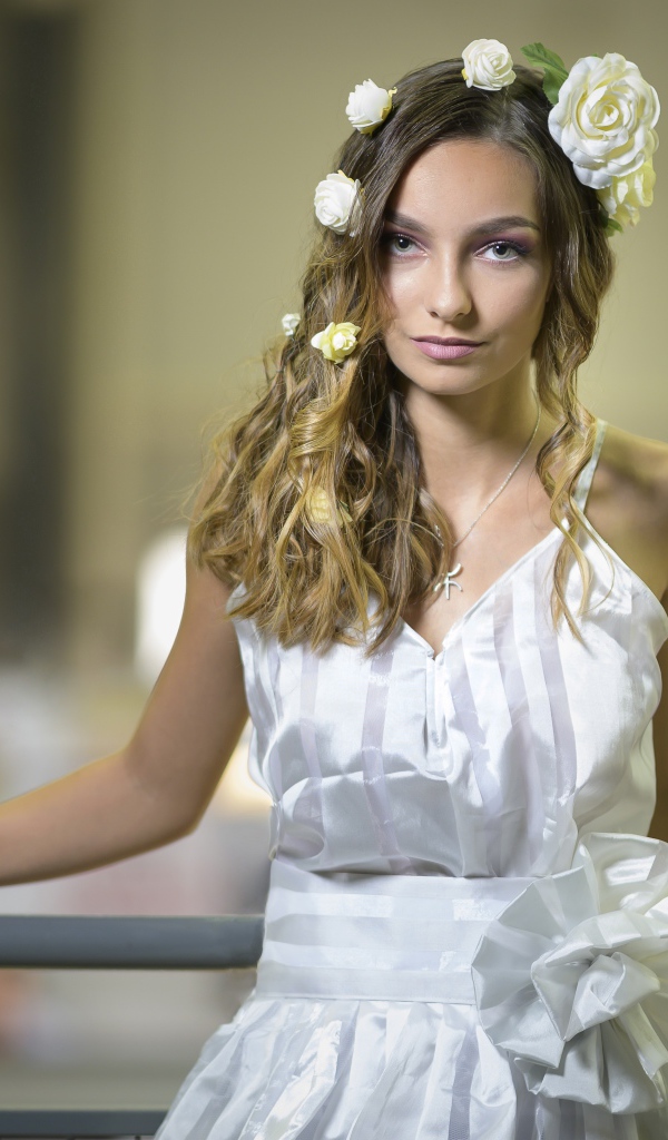 Красивая девушка в белом платье с цветами в волосах 