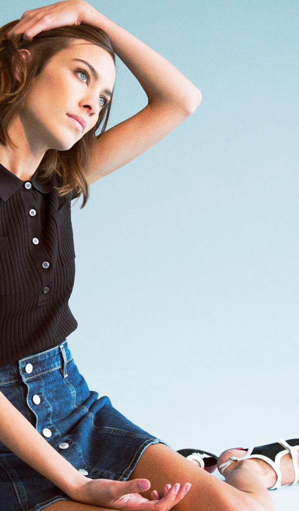 Модель Алекса Чанг сидит на голубом фоне