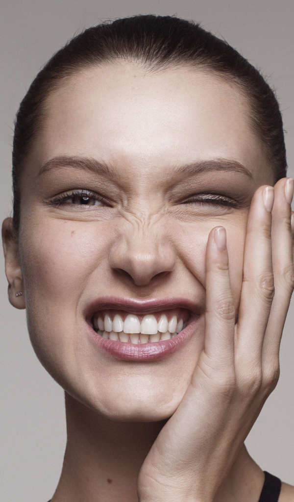 Модель Белла Хадид корчит гримасы на сером фоне