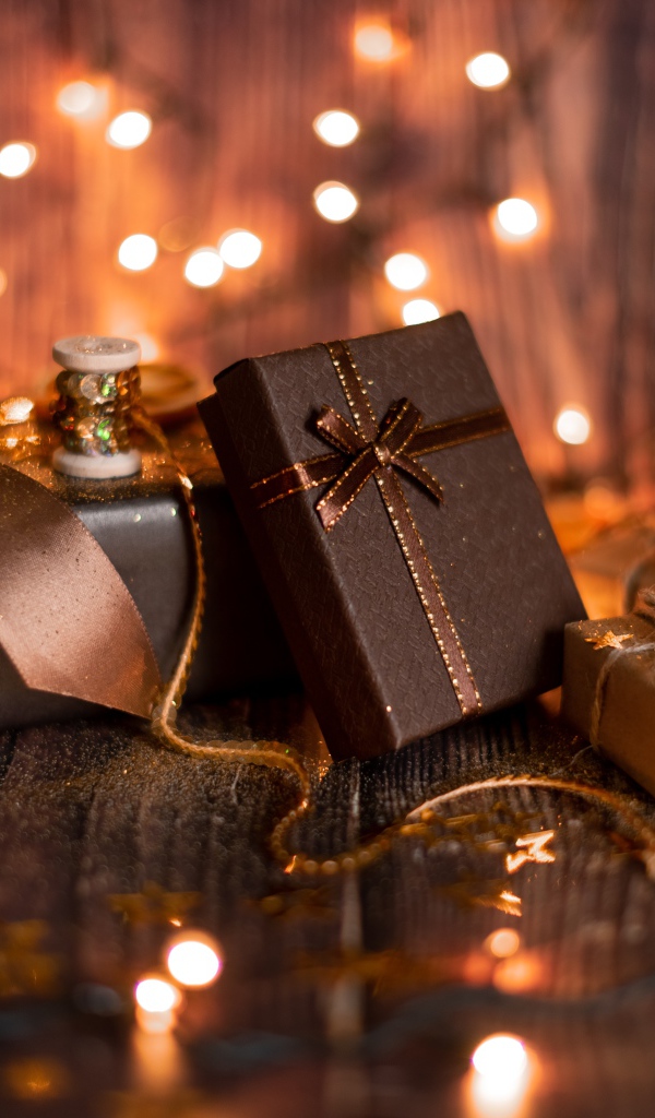 Много подарков на деревянном фоне с гирляндой