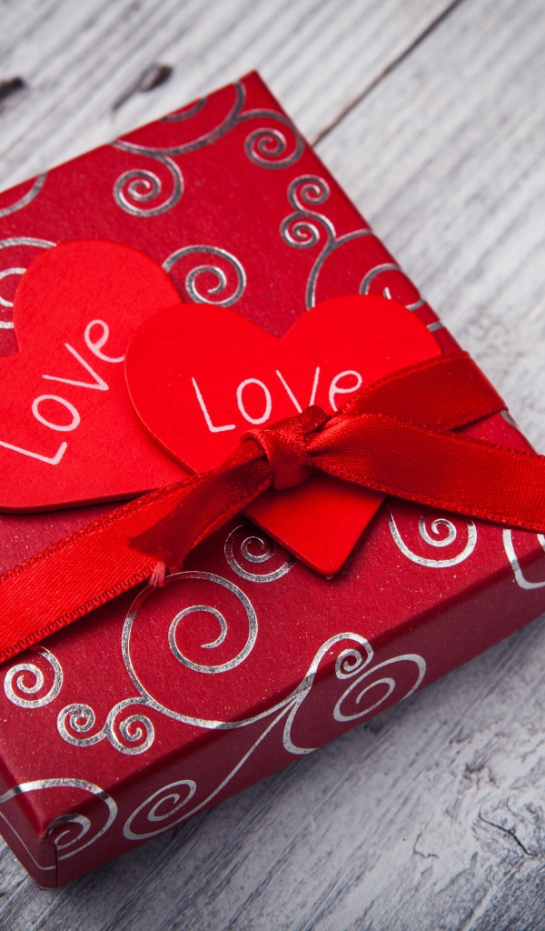 Gift with red hearts on a wooden table