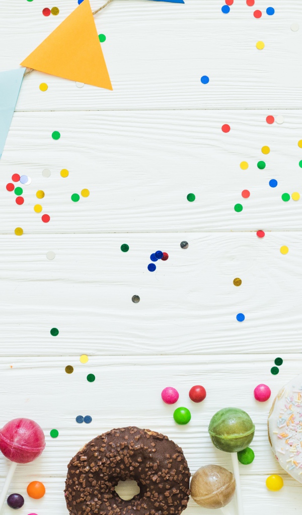 Пончики с глазурью и конфеты на праздничном фоне