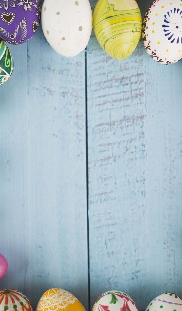 Много крашеных яиц на голубом фоне, шаблон для открытки на Пасху