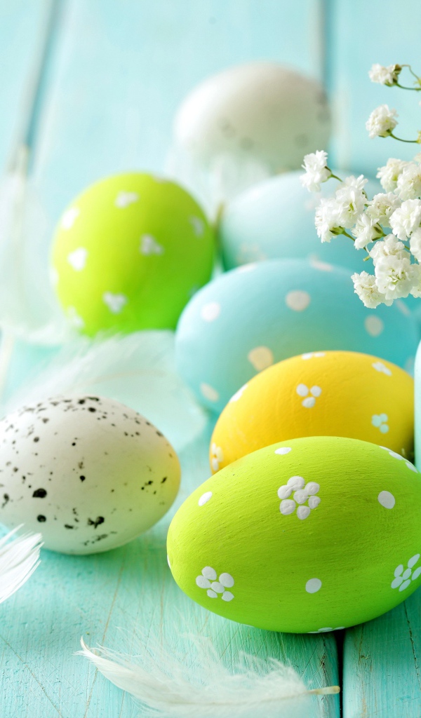 Крашеные яйца с цветами на голубом столе 