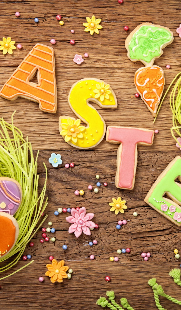 Вкусное разноцветное пасхальное печенье на деревянном столе