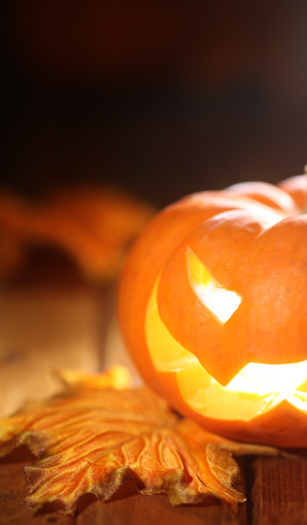 Светящаяся тыква на столе на Хэллоуин