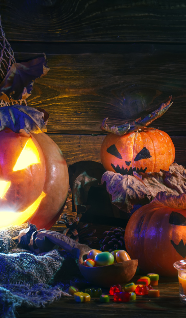 Зловещие тыквы на столе со сладостями на праздник Хэллоуин 