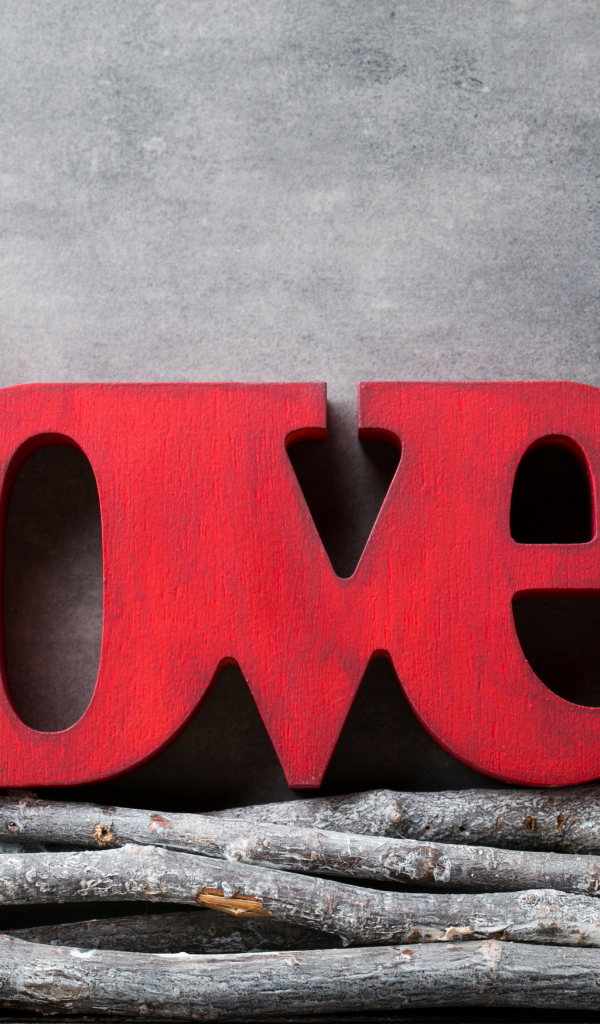 Большая надпись любовь на английском на фоне серой стены 