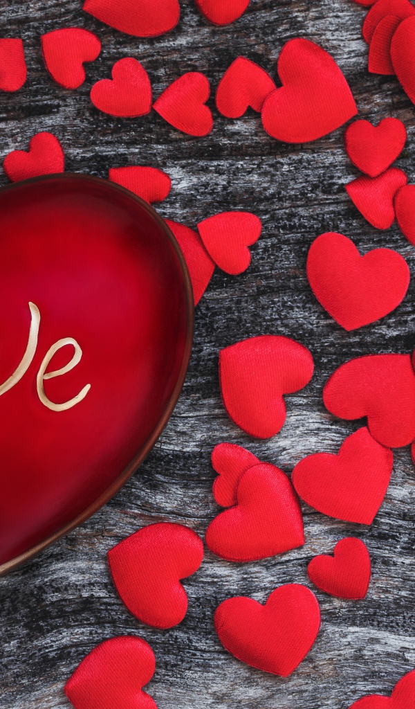 Большое красное сердце на деревянном фоне с маленькими сердечками