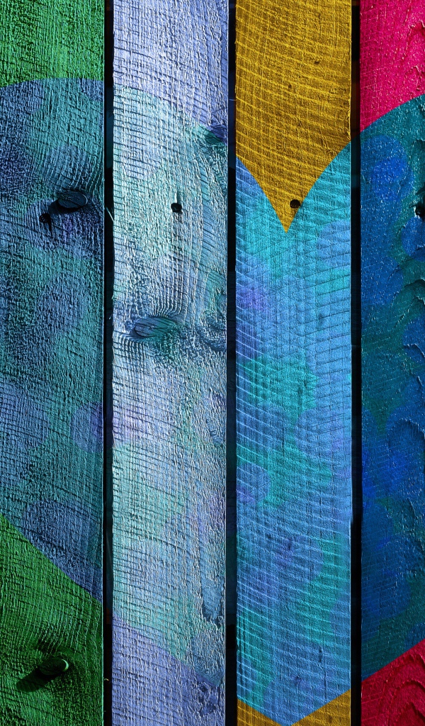 Голубое сердце нарисовано на разноцветном заборе